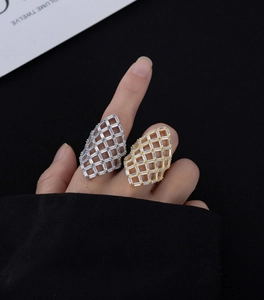Detail of hollow mesh grid rings in gold and silver finish with pave-set sparkling zircons