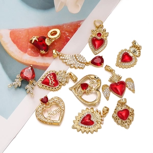 Macro shot of 18K gold plated heart and wing pendants with red cubic zirconia