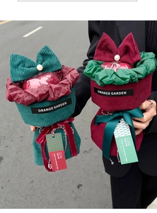Close-up of velvet Christmas apple gift bags with bows and pearls in red and green