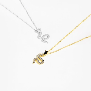 Minimalist snake pendant necklace in gold and silver finish with crystal pavé and black gems