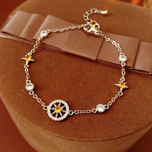 Macro detail of silver star compass bracelet featuring yellow and white zircon stones