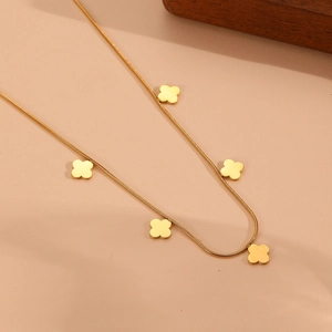 Gros plan d'un collier trèfle à quatre feuilles doré avec cinq pendentifs élégants