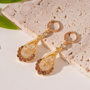 Detail of vintage teardrop earrings with golden mesh and zircon rhinestones on stone
