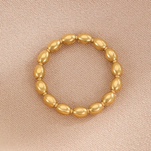 Minimalist gold beaded geometric stainless steel ring on soft pink textured fabric