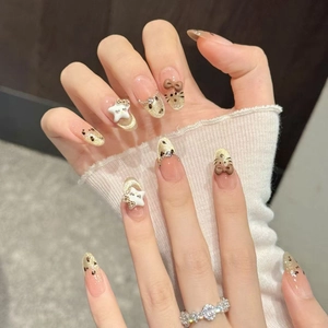 Handmade almond press-on nails with pink cat-eye effect, leopard print, and bow charms