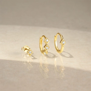 Macro shot of S925 sterling silver stamp on gold earrings with white zircon accents