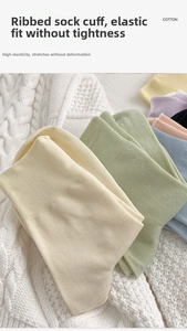 Close-up of colorful rib-knit cotton socks in pastel tones on a soft white knit blanket