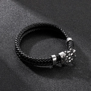 Macro detail of nautical double-layer leather bracelet with stainless steel helm charm