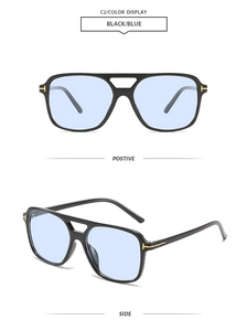 Detail of pilot sunglasses with blue lenses and golden T-shaped metal hinges