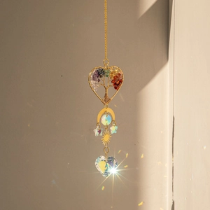 Detail of brass heart tree of life suncatcher with crystal creating rainbow light