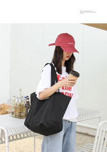 Outdoor lifestyle shot of a spacious black canvas tote bag with textured finish