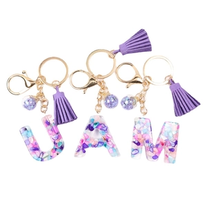 Resin crystal initial keychain with U, A, M letters, purple tassel and golden lobster clasp
