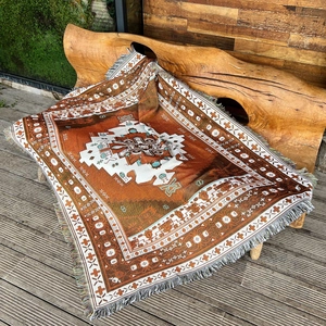 Detailed close-up of woven bohemian camping blanket with tribal patterns and fringes