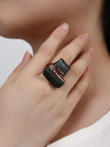 Detailed view of an adjustable bronze ring with two raw black tourmaline stones