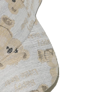 Detail of beige baseball cap with high-density jacquard bear patterns and text