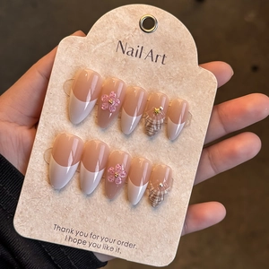 Macro detail of almond press-on nails with 3D white flowers and pearl accents