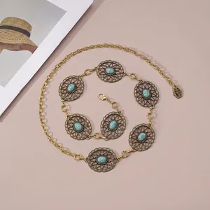 Vintage bohemian gold waist chain with turquoise circular links on a soft pink background