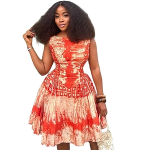 Sleeveless A-line dress with orange batik print and pleated waist on model
