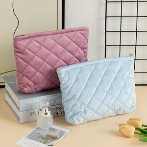 Quilted corduroy cosmetic bag in pink and blue colors with checkered texture and metal zipper