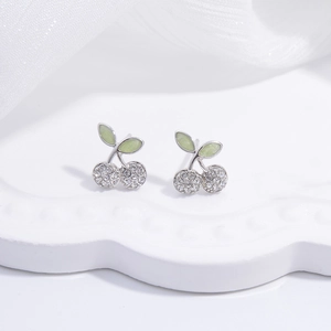 Close-up of S925 silver cherry stud earrings with clear zircons and green enamel leaves