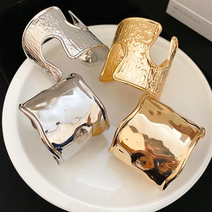 Irregular wide cuff bracelets set with hammered gold and silver mirror finishes