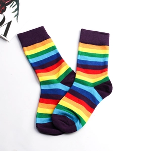 Detailed close-up showing vibrant rainbow stripes and knit texture of mid-calf socks