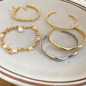 Set of 18k gold plated honeycomb bangles and pearl bracelets displayed on ceramic tray