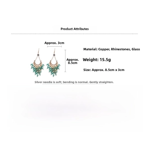 Macro detail of drop fringe earrings showing copper base and green crystal beads