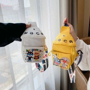 Detail of yellow and white canvas chest bags for kids featuring cute cartoon character prints