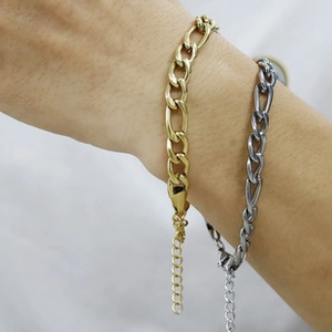 Close-up of gold and silver chunky chain bracelets on a model's wrist with adjustable links