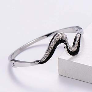 Elegant wave-shaped stainless steel bracelet with inlaid black and white rhinestones