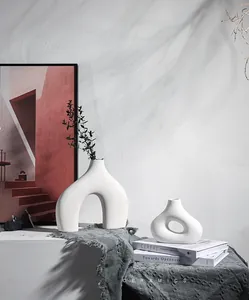 Detail van minimalistische witte keramische vazen met organische boog- en holle ringvormen