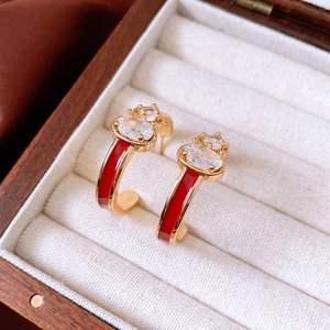 Detail of 18k gold plated earring with red enamel and shimmering cubic zirconia stones