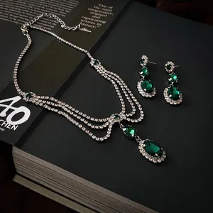 Elegant emerald green oval jewelry set including tassel necklace and teardrop earrings