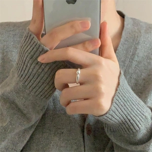 Close-up of minimalist 925 sterling silver beaded open ring on a model in knitwear