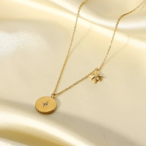 Detailed close-up of 18K gold-plated starburst medallion necklace on champagne silk