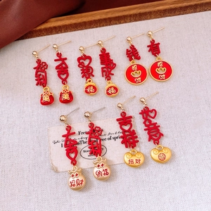 Detailed macro of Chinese New Year red lucky bag tassel earrings with golden charms