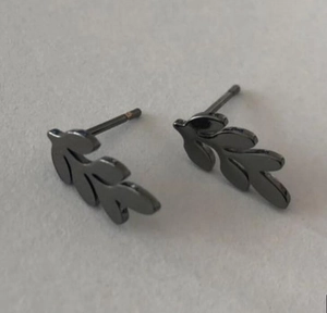 Close-up of minimalist leaf-shaped ear studs in charcoal black finish with vine textures