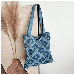 Close-up of retro denim tote bag featuring star pattern patchwork and frayed edge details