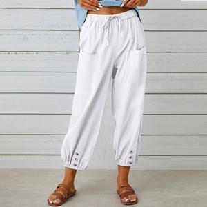 Dettaglio dei pantaloni bianchi in cotone e lino con polsini bottonati e tasche laterali