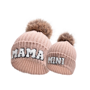 Dettaglio dei berretti coordinati rosa cipria mamma e mini con pompon e ricami