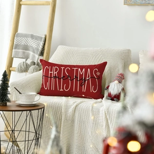 Close-up of a red linen Christmas cushion cover with white Merry Christmas lettering