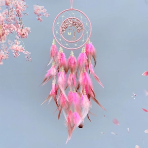 Macro shot of pink feathers and life tree crystal stone detail on a dream catcher