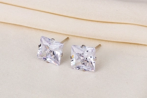 Macro detail of square-cut cubic zirconia stud earrings with silver four-prong setting