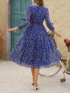 Vue arrière extérieure d'une robe mi-longue fleurie bleue avec manches longues et coupe A