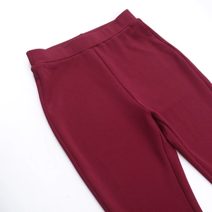 Dettaglio dei pantaloni in maglia a coste bordeaux che mostra la trama e l'elastico
