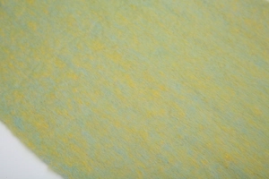 Close-up of yellow and green boucle yarn scarf showing soft fringe and fuzzy texture
