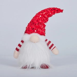 Gnome Christmas decoration with red sequin hat and warm light on gray background