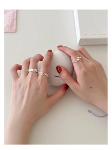 Vue détaillée d'un ensemble de bagues en argent avec motif cœur évidé et chaîne ondulée