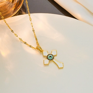 Goldene Kreuzkette mit weißem Emaille-Inlay und blauem Evil Eye Zirkon auf weißem Grund